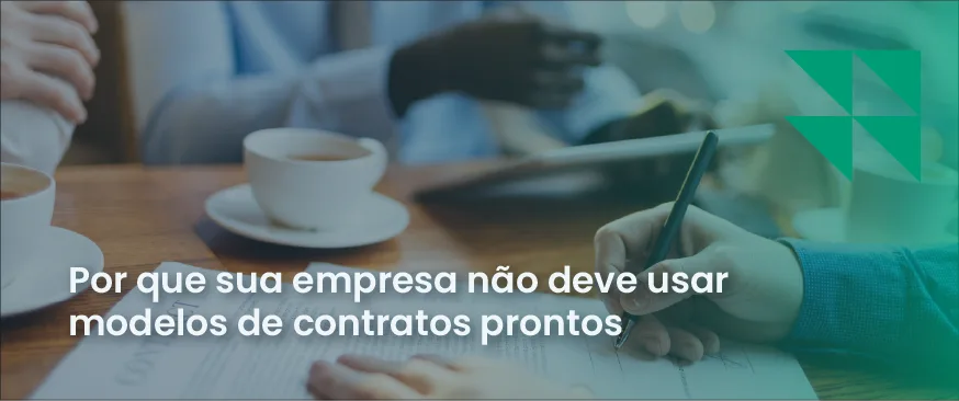 Homem em reunião assinando contrato enquanto outros homens tomam café Escrita: Modelos de contratos prontos